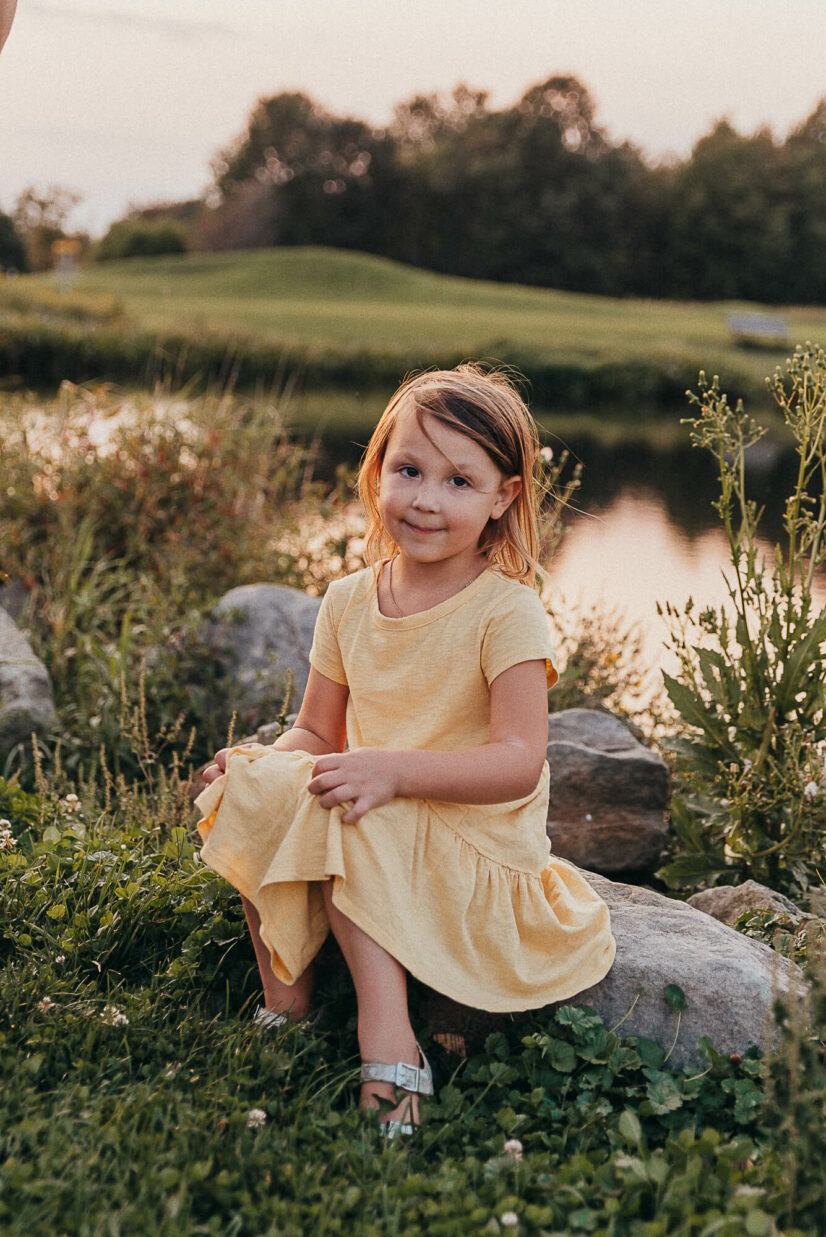 little girl in yellow dress sitting on a rock near the lake Toys Stores in Cleveland
