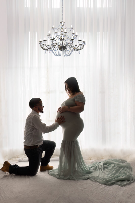 Dad kneeling on ground in front of mom during maternity photography session Cleveland Akron Photography Services