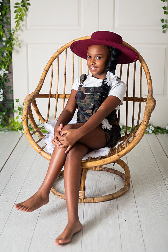 girl sitting on wicker chair for Hoy’s Toys photography session