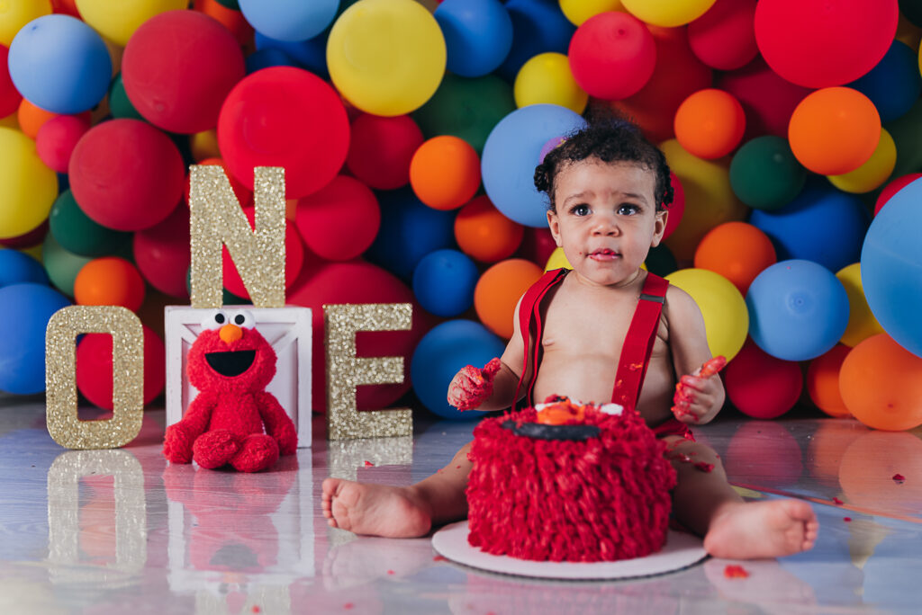 Boy sitting on ground for Elmo Cake Smash Things to do in Cleveland with Kids