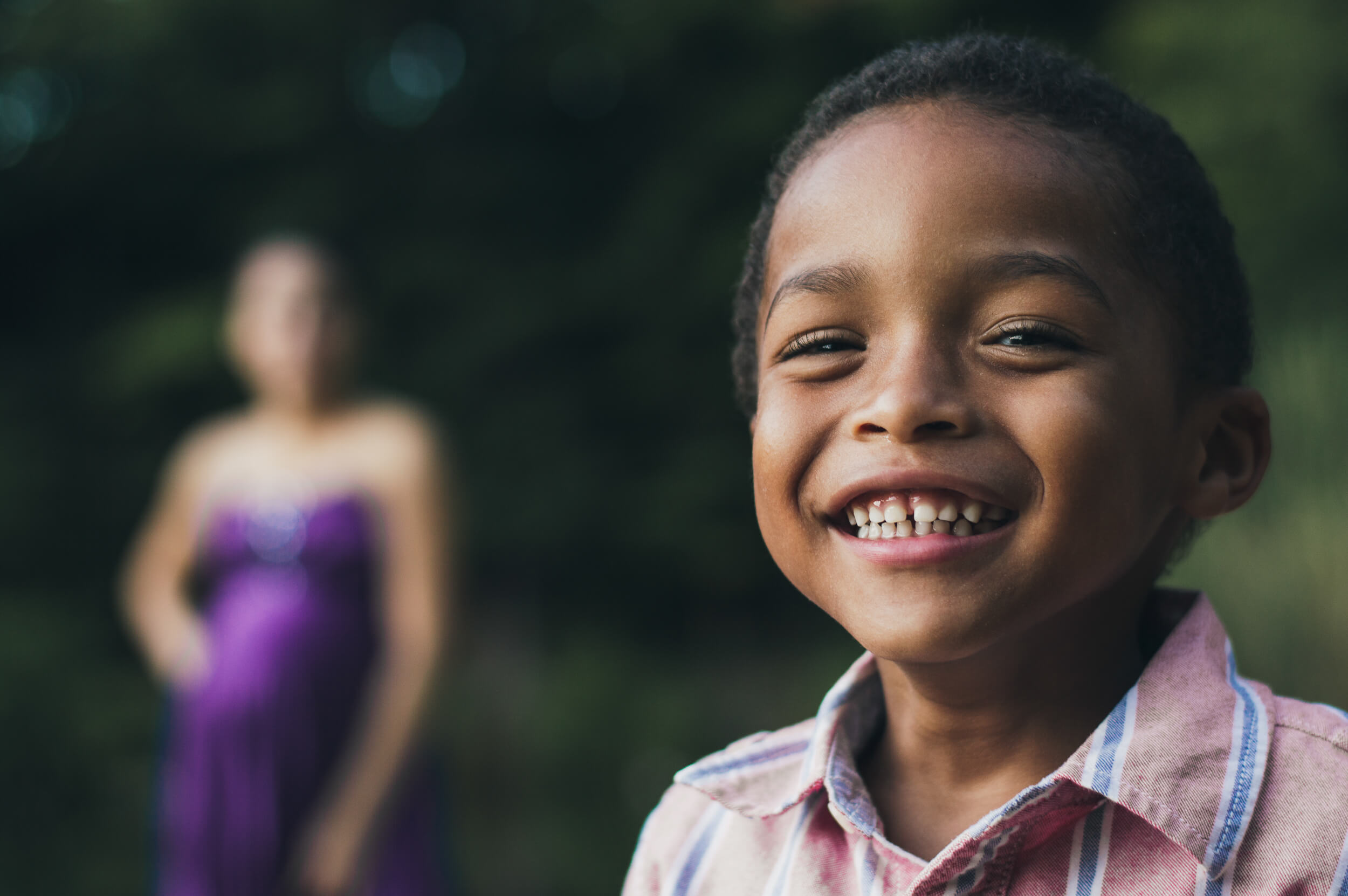 Boy smiling at camera while mother standing the background Camelot Lanes