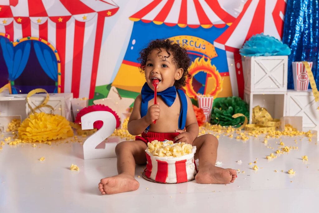 Child eating cake during a carnival cake smash Tadpoles & Tiddlers