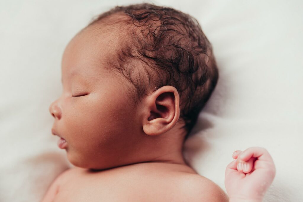 newborn sleeping with a closed fist for Cherub's Blanket