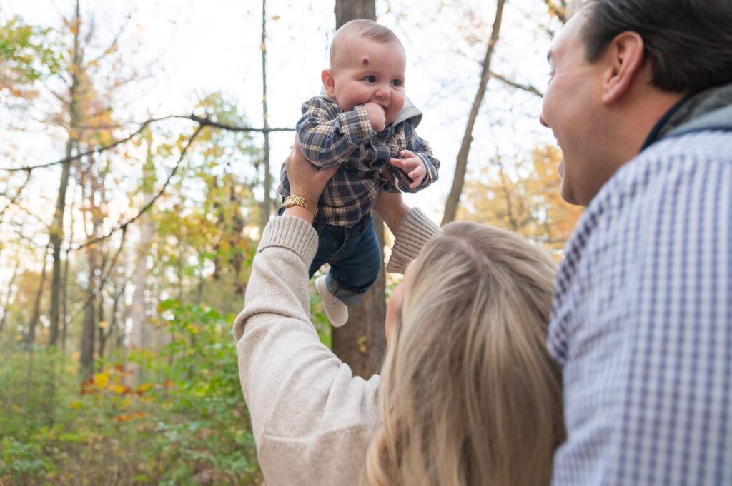 Parents playing with their baby during an outdoor fall family photo session in Northeast Ohio