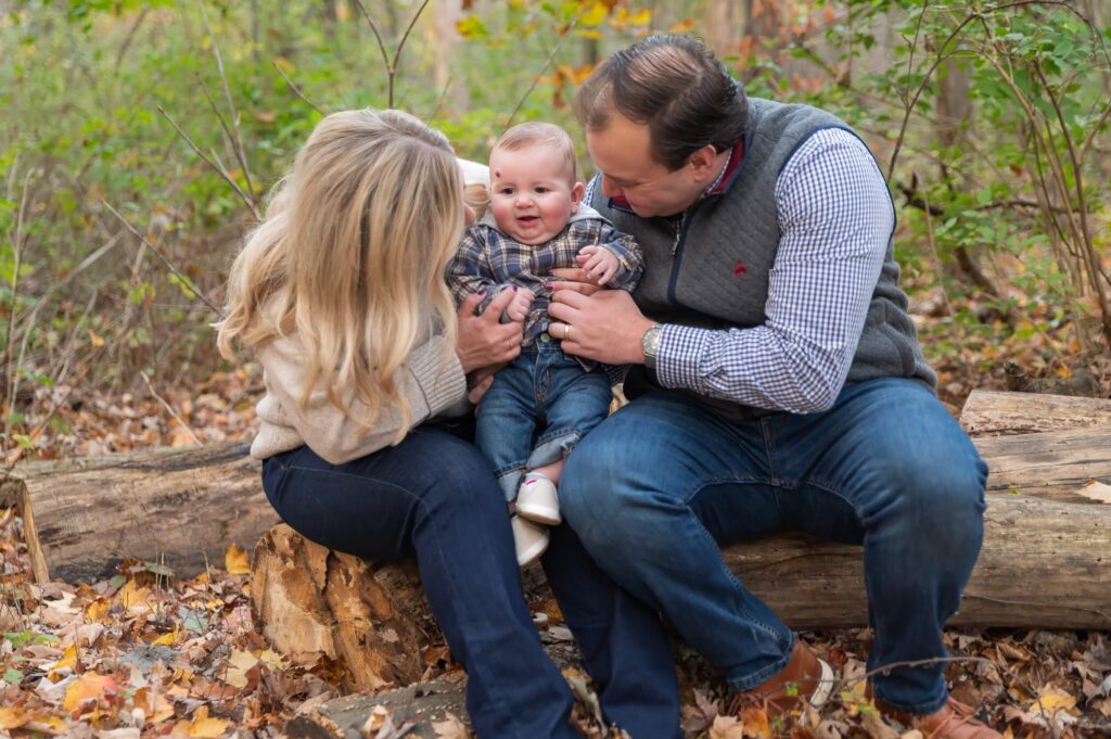 Mom and dad cuddling their baby during a candid fall family photography session in Northeast Ohio