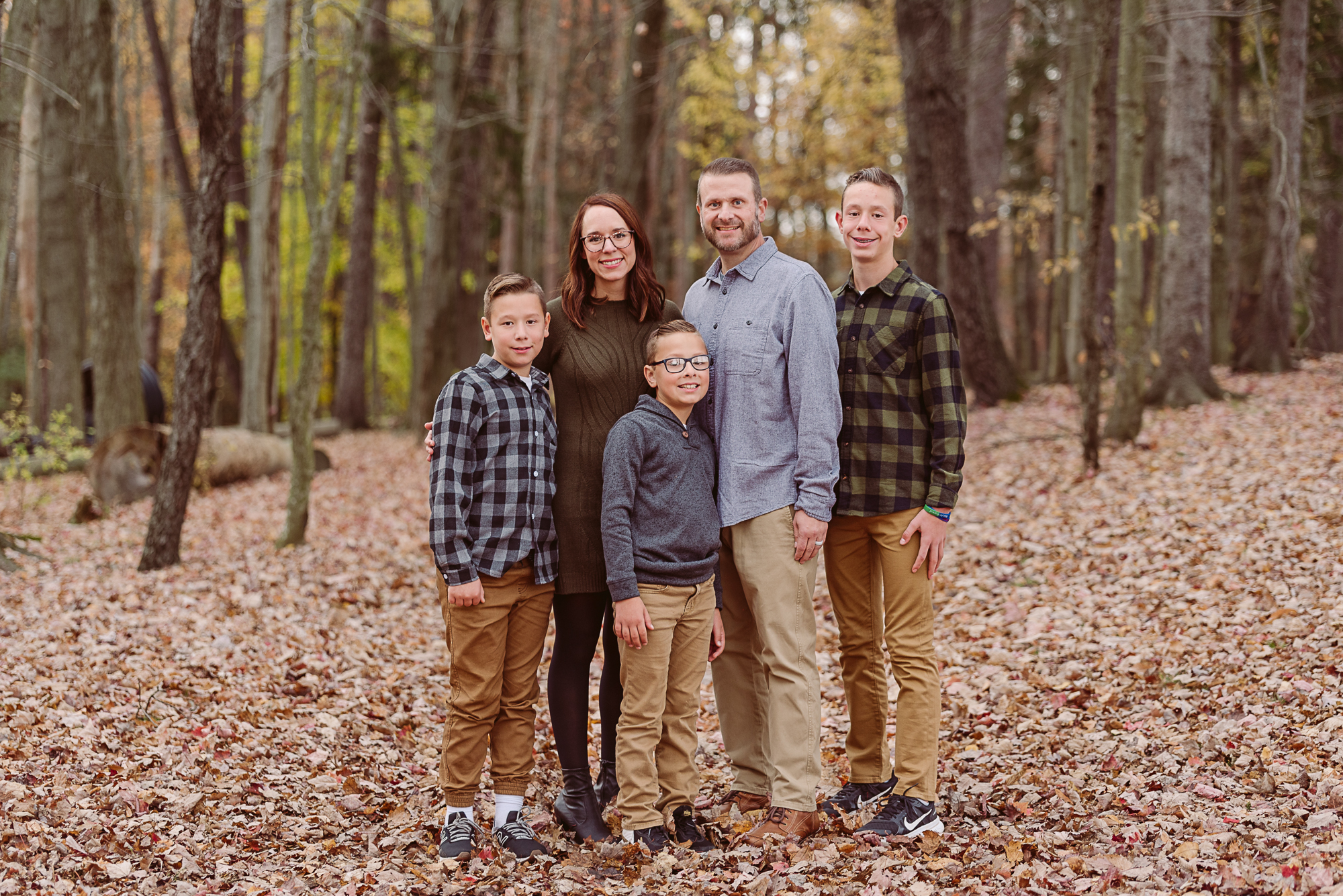 Family of five surrounded by autumn leaves during a fall family photo session in Northeast Ohio