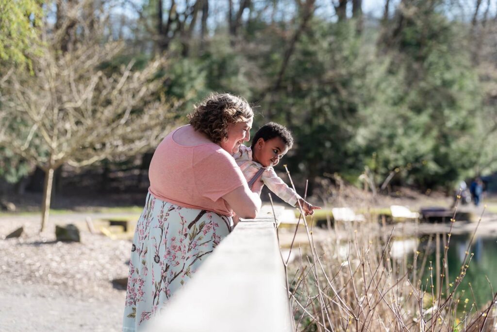 Mom holding her toddler on a wooden boardwalk during a candid Northeast Ohio family photography session